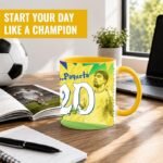 Desk scene with a yellow soccer-themed mug, notebook, pen, photo, plant, laptop, and a soccer ball; banner reads 'Start your day like a champion'.