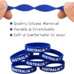 Blue silicone stretch bracelet held by fingers with stack of AUSTRALIA wristbands below, showing product theme and features.